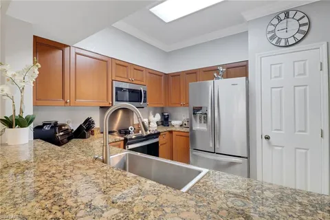 a kitchen with stainless steel appliances granite countertop a refrigerator sink and stove