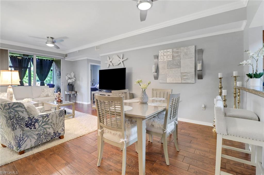 10126 Villagio Palms Way, Unit 107 Estero, FL 33928 - Photo 8 of 43 a view of a dining room with furniture wooden floor and chandelier