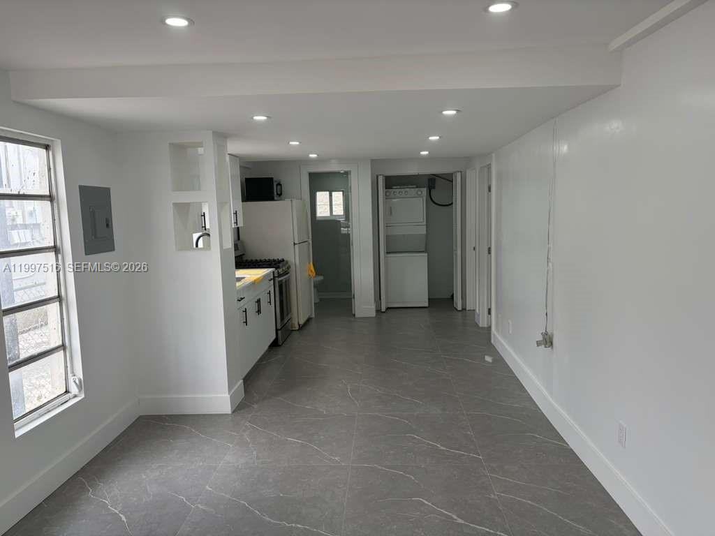 a view of a hallway with kitchen and window