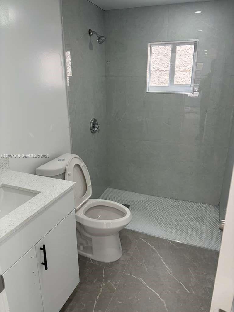 1011 Southwest 5th Street, Unit 1 Miami, FL 33130 - Photo 10 of 12 a bathroom with a toilet sink and vanity