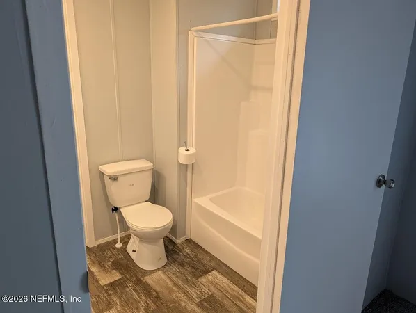a bathroom with a toilet and a shower