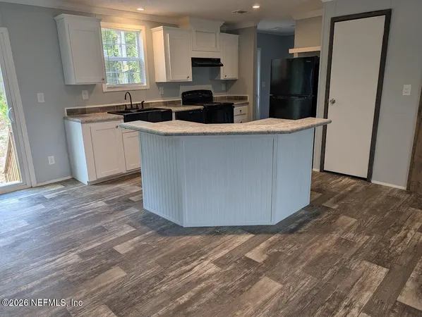 a kitchen with stainless steel appliances granite countertop a refrigerator a sink a stove a microwave and wooden floors