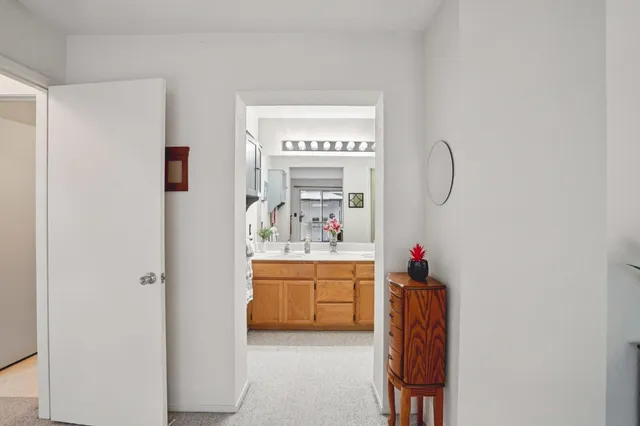 a view of a bedroom with baby bed and window