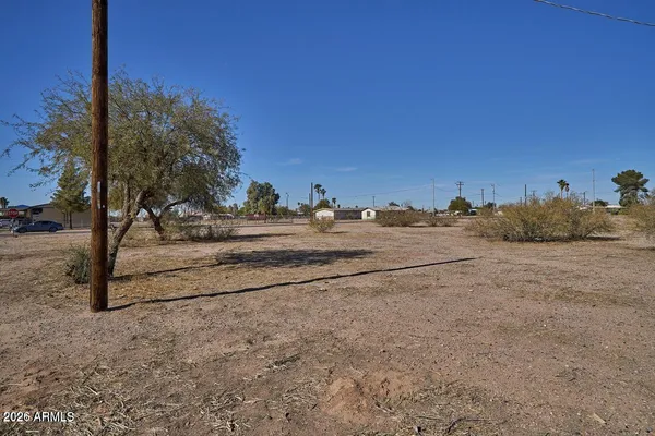 a view of dirt road with a building in the background