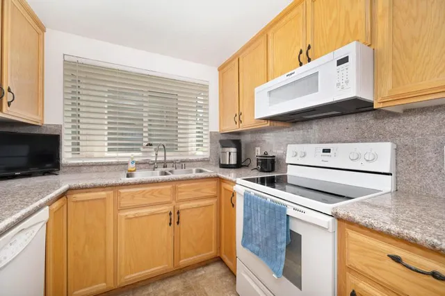 a kitchen with stainless steel appliances granite countertop a sink and cabinets with wooden floor