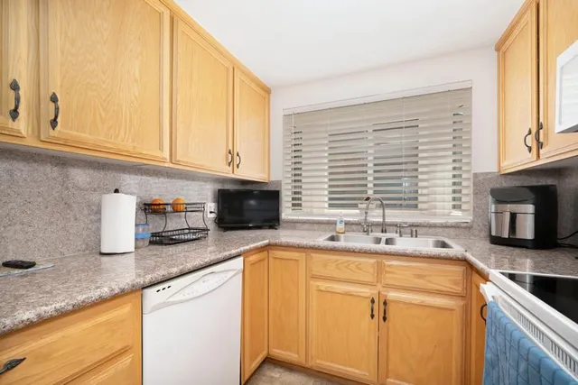 a kitchen with stainless steel appliances granite countertop a sink a stove and cabinets