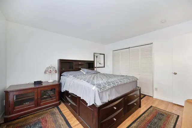 a bedroom with a bed and wooden floor