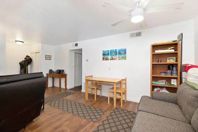 a living room with furniture a rug and white walls