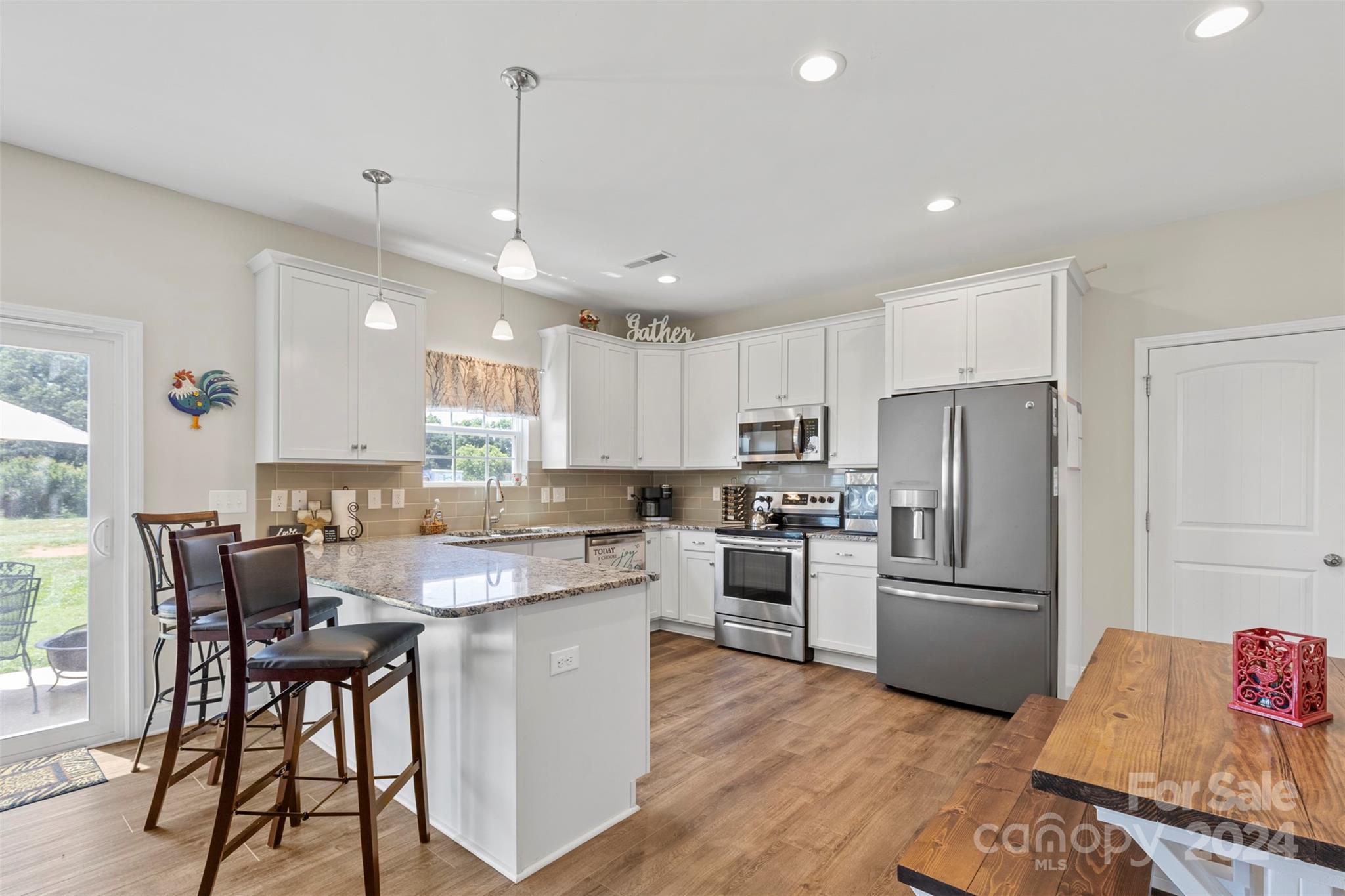 2902 New Salem Road Monroe, NC 28110 - Photo 14 of 28 a kitchen with kitchen island a refrigerator a stove a dining table and chairs