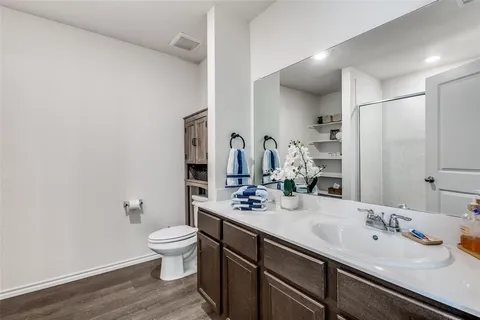 a bathroom with a double vanity sink toilet and mirror