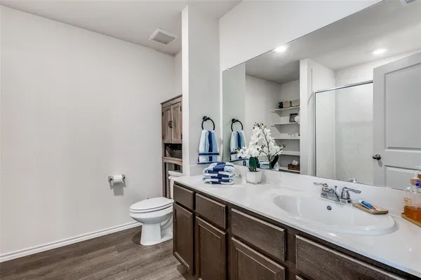 a bathroom with a double vanity sink toilet and mirror