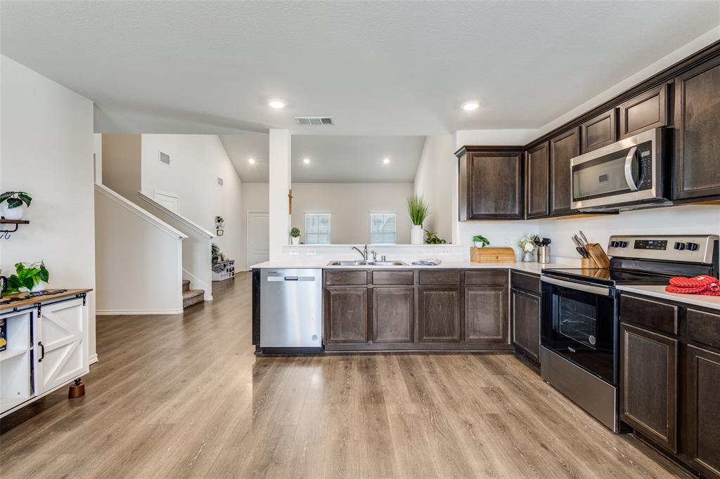 305 Ginger Avenue Anna, TX 75409 - Photo 9 of 28 a kitchen with stainless steel appliances granite countertop a stove and a sink