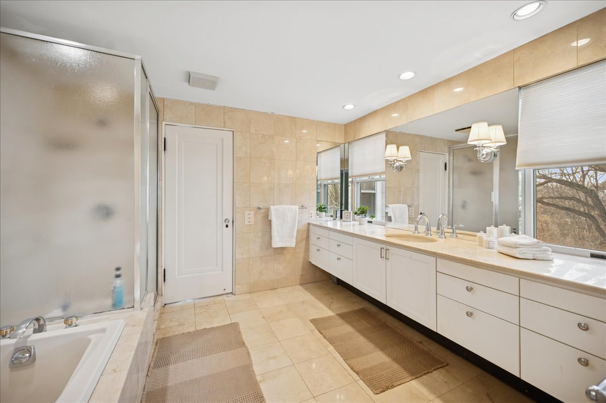 2085 Stirling Road Bannockburn, IL 60015 - Photo 24 of 48 a large bathroom with a double vanity sink large mirror and shower