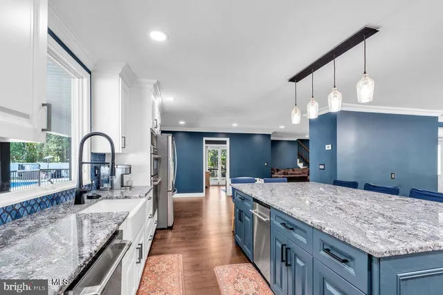 a kitchen with granite countertop a table chairs microwave and refrigerator