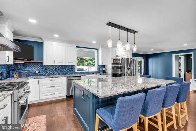 a large kitchen with granite countertop lots of counter space and sink