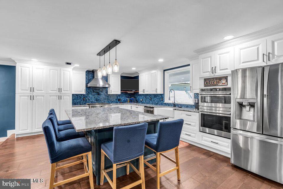 225 West Bird Village Road Jackson, NJ 08527 - Photo 20 of 66 a kitchen with granite countertop a table chairs microwave and refrigerator