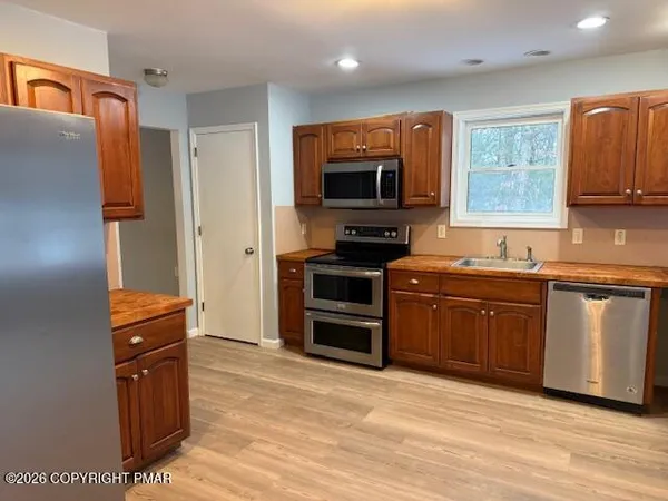 a kitchen with granite countertop a refrigerator stove top oven and sink