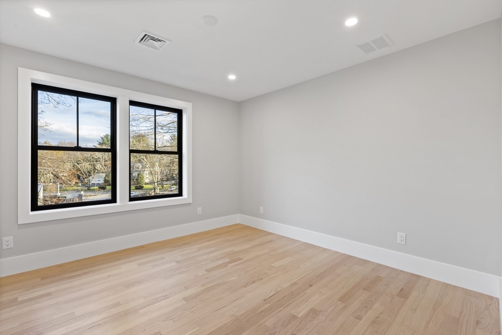 10 Webber Avenue, Unit 201 Bedford, MA 01730 - Photo 22 of 35 an empty room with wooden floor and windows