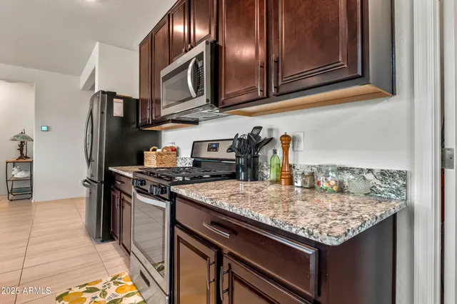 a kitchen with granite countertop stainless steel appliances and wooden cabinets