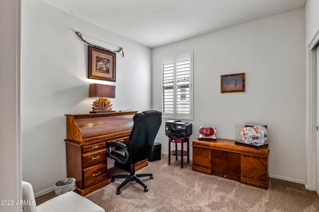 a view of a workspace with furniture and a window