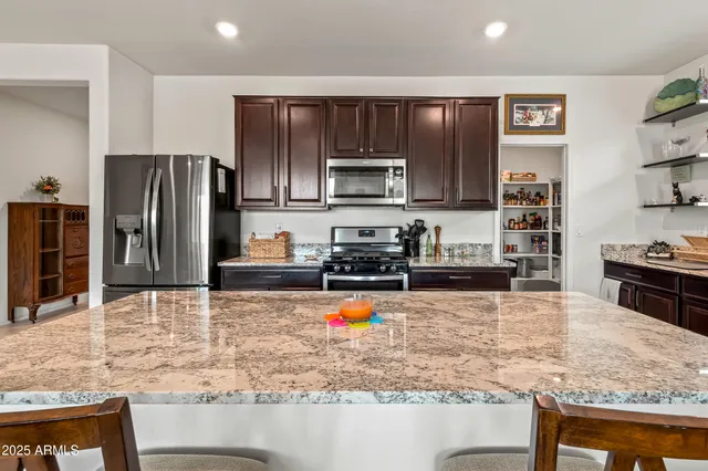 a kitchen with stainless steel appliances granite countertop a refrigerator stove and oven