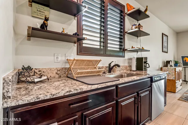 a kitchen with granite countertop a sink and cabinets