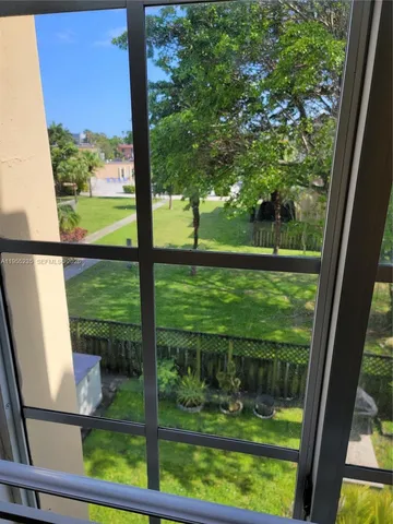 a view of an empty room with wooden floor and closet area