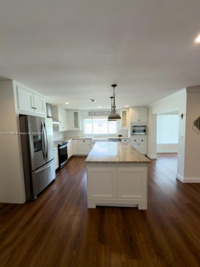 2224 Tinker Street Port Charlotte, FL 33948 - Photo 8 of 42 a large white kitchen with a refrigerator a stove a microwave and a wooden floor