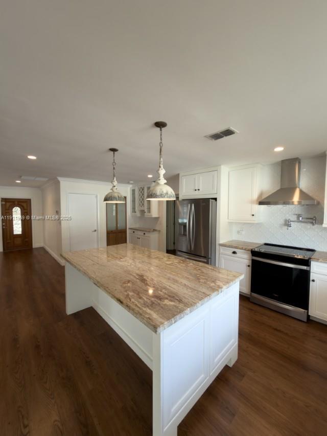 2224 Tinker Street Port Charlotte, FL 33948 - Photo 9 of 42 a large kitchen with stainless steel appliances kitchen island a large counter top and a stove