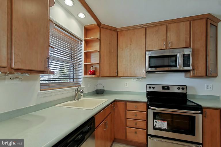 9709 Saxony Road Silver Spring, MD 20910 - Photo 12 of 24 a kitchen with stainless steel appliances a stove sink microwave and cabinets