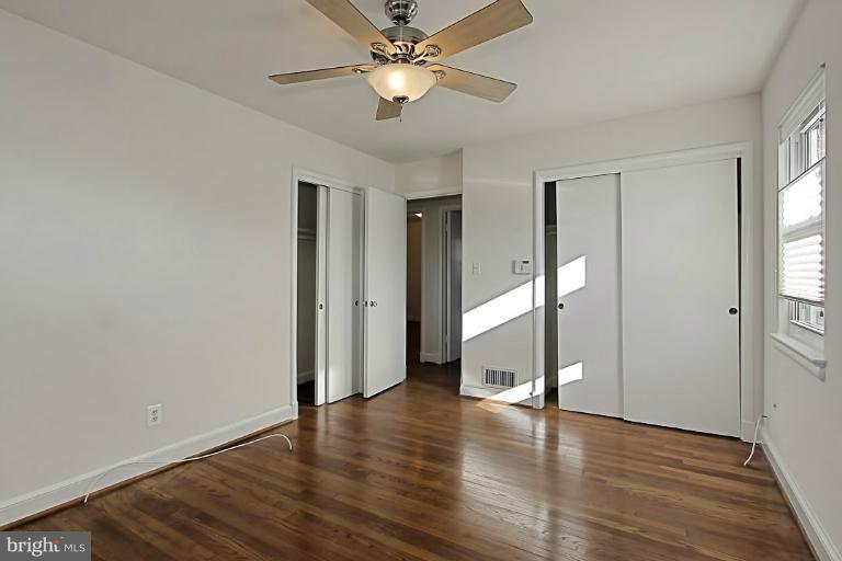 9709 Saxony Road Silver Spring, MD 20910 - Photo 13 of 24 a view of an empty room with wooden floor and a ceiling fan