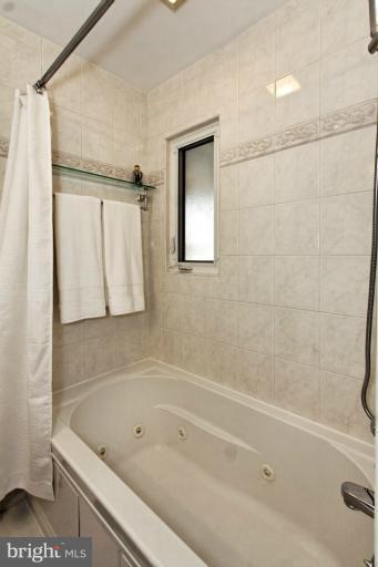 9709 Saxony Road Silver Spring, MD 20910 - Photo 23 of 24 a bathroom with a tub a sink and a shower