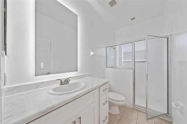 a view of an empty room with wooden floor and a fireplace