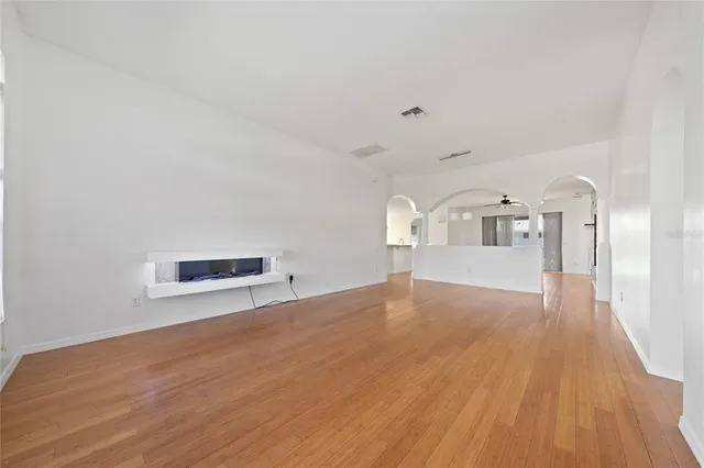 a view of empty room with wooden floor