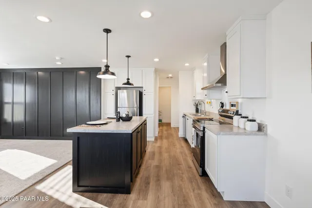 a kitchen with kitchen island stainless steel appliances a sink stove and refrigerator