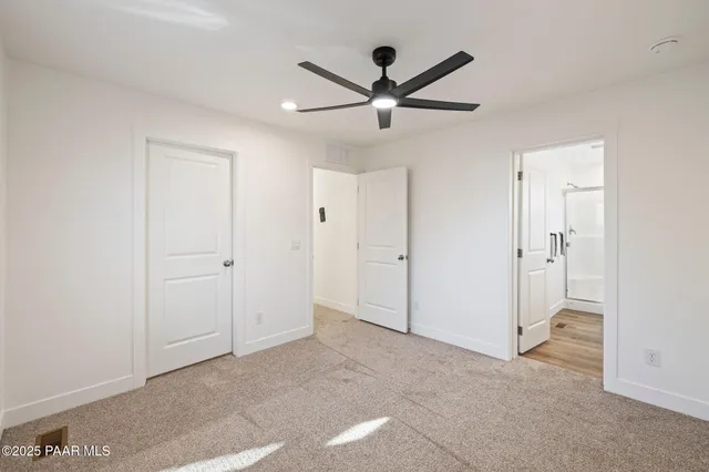 a view of a livingroom with a ceiling fan & entryway