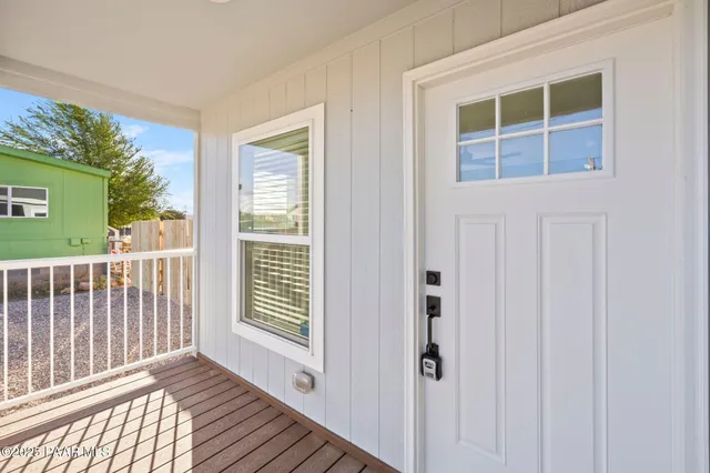 a view of a porch with wooden floor and a window