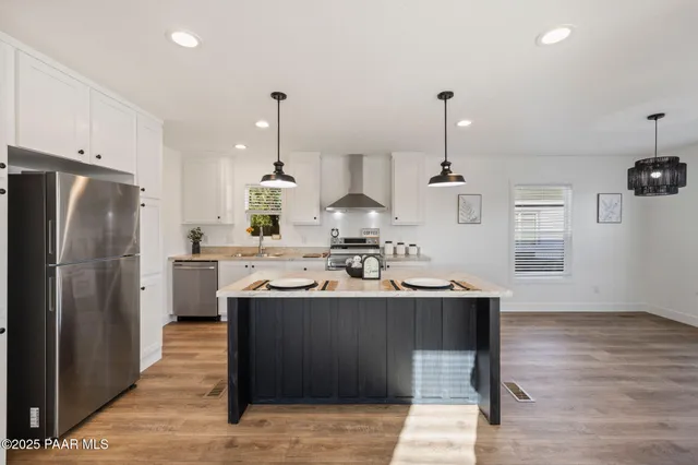 a kitchen with a sink a refrigerator and wooden floor
