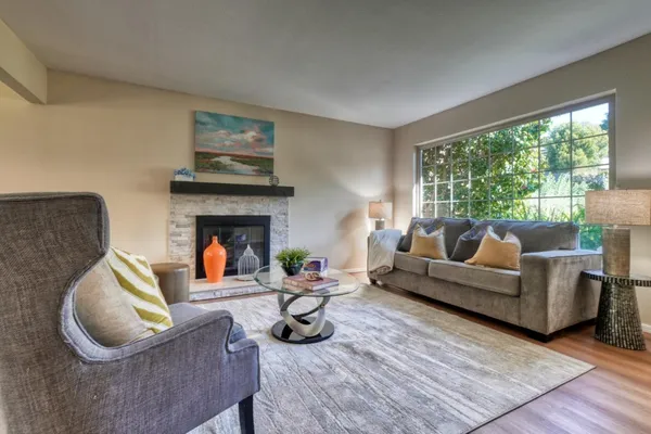 a living room with furniture a fireplace and a large window