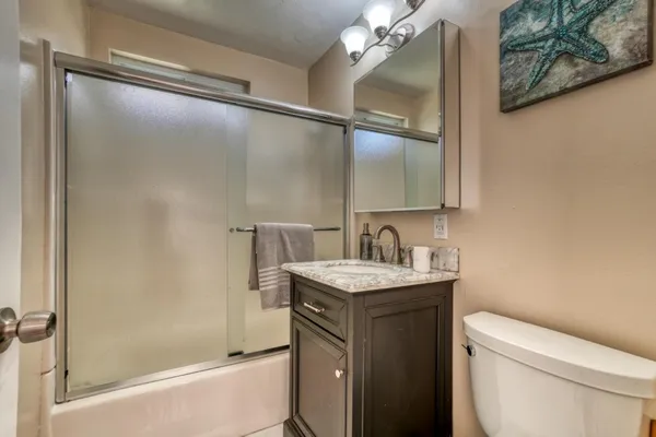 a bathroom with a sink a toilet and shower