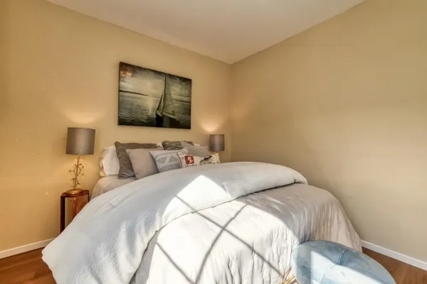a bedroom with a bed and a painting on the wall