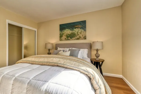 a bedroom with a bed and a painting on the wall