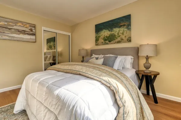 a bedroom with a bed and a painting on the wall