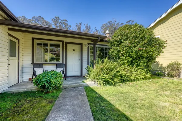 a view of yellow house with a yard
