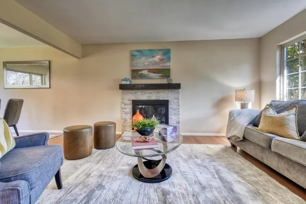 a living room with furniture a fireplace and a window