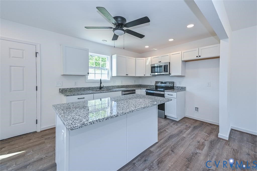 606 West Point Drive Ruther Glen, VA 22546 - Photo 9 of 30 a kitchen with granite countertop a sink appliances cabinets and wooden floor