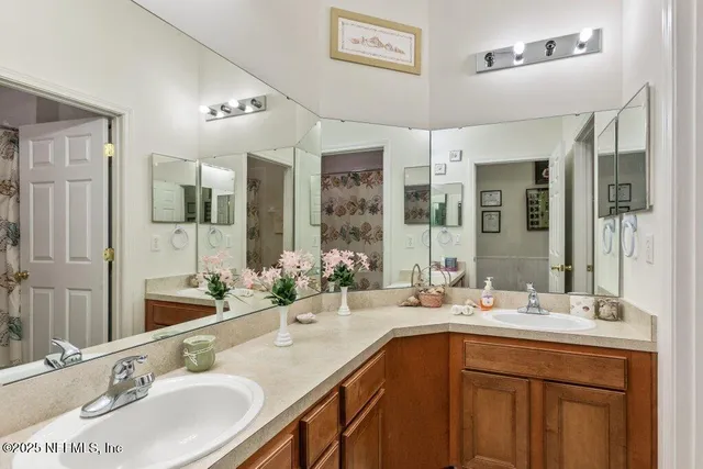 a bathroom with double vanity sinks and a mirror