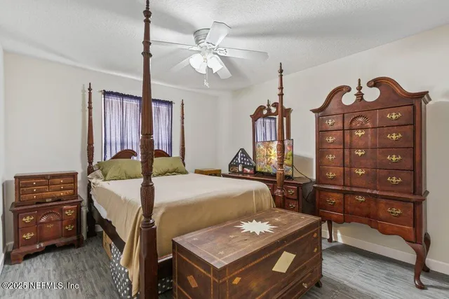 a bedroom with a bed a dresser and chair