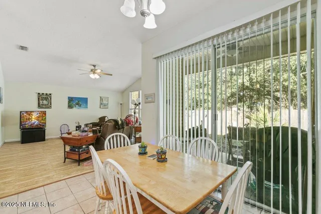 a view of a dining room and livingroom with furniture wooden floor a chandelier