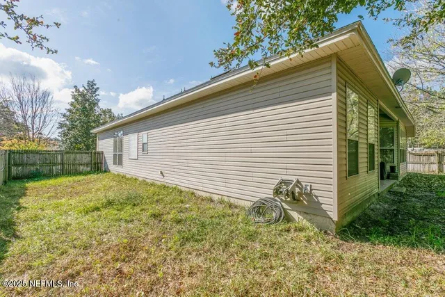 a view of backyard of house and car parked